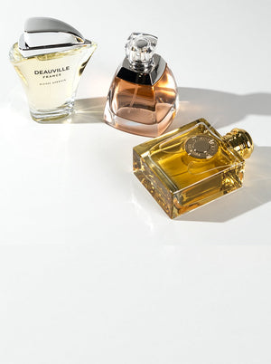 Deauville France, Vera Wang, and Burberry Goddess perfumes displayed on a white background, highlighting top women's fragrance bestsellers.