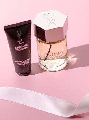 Yves Saint Laurent L'Homme fragrance and matching all-over shower gel set displayed on a pink background with a white ribbon.