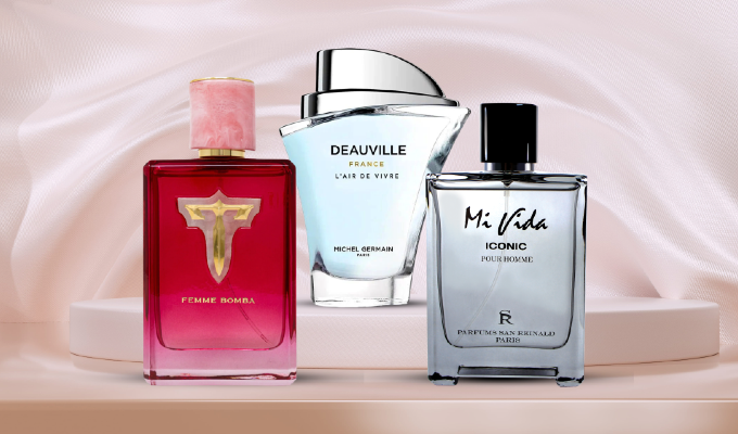 Three fragrance bottles displayed on a pale pink satin background