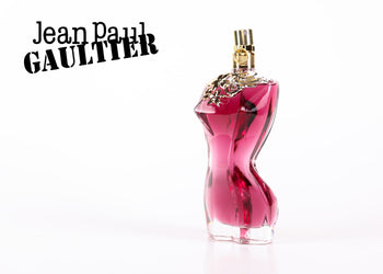 Jean Paul Gaultier pink perfume bottle with a gold spray cap on a clean white background with soft lighting. 5