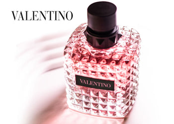 Valentino perfume bottle with pink-toned glass and studded design on a soft white background with elegant lighting and shadows. 2
